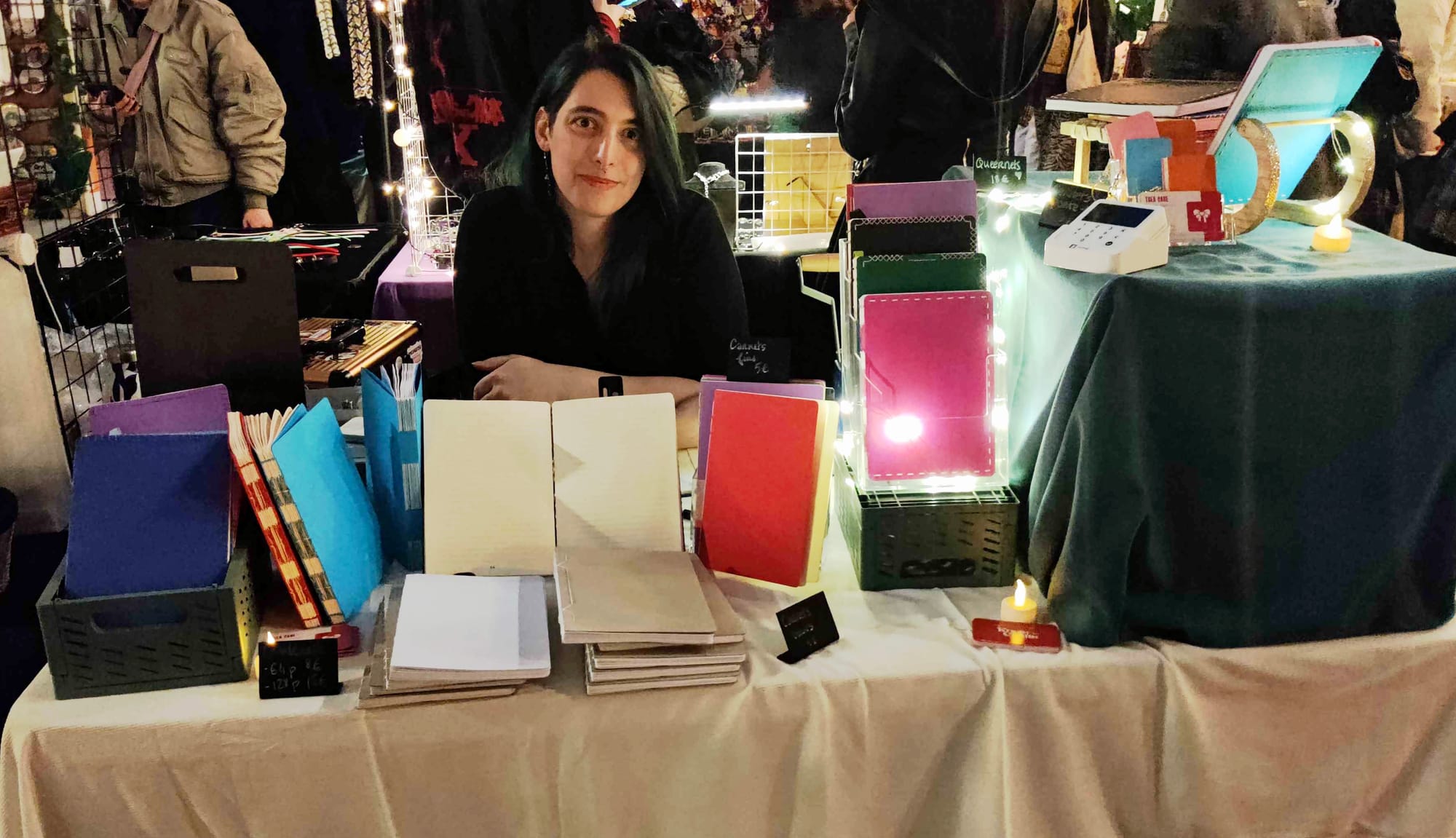 Moi derrière un stand avec plein de carnets posés